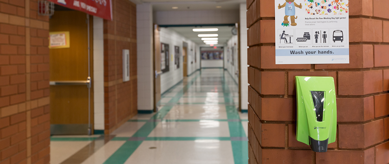 Symmetry Stealth Alert Dispenser on a wall in a school hallway